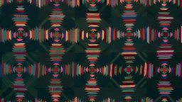 A geometric quilt with repeating concentric diamond and striped patterns in red, pink, orange, and blue tones on a dark background.