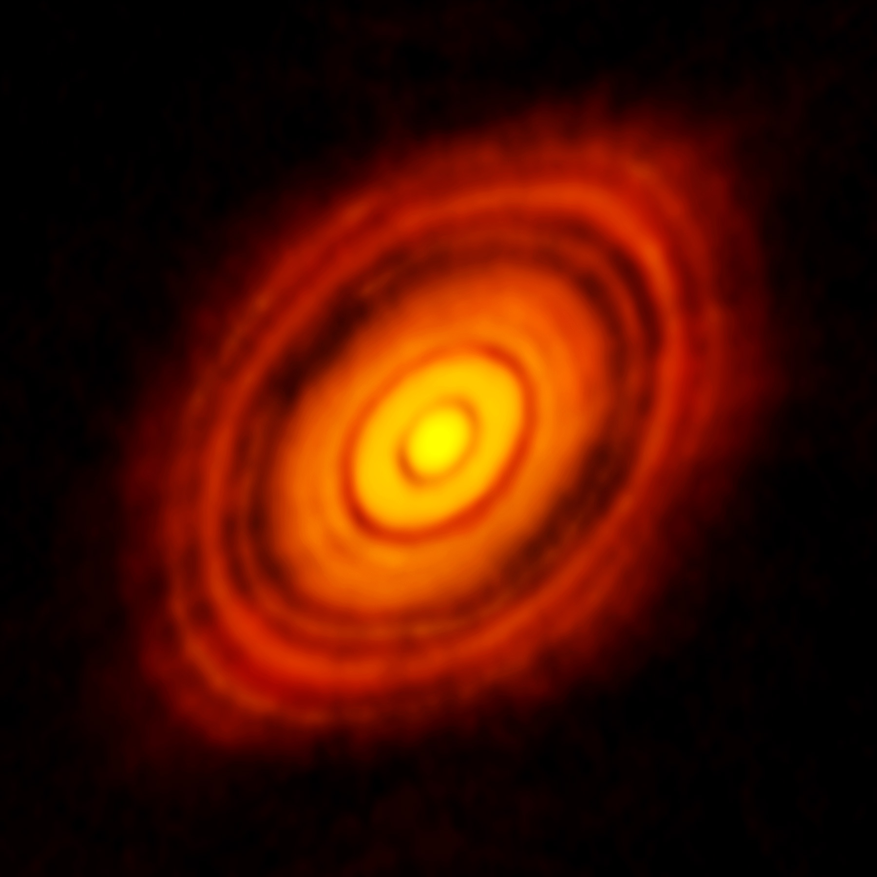 Bright, concentric rings surrounding a glowing central core, resembling a protoplanetary disk on a dark background—a snapshot capturing the JWST's glimpse into star system birth.
