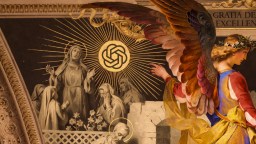 A mural shows an angel pointing toward a golden emblem, with rays emanating. Monks stand in reverence below, surrounded by flowers and architectural details.