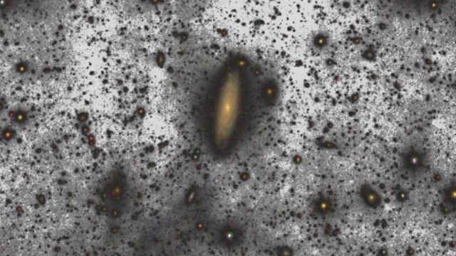 The spiral galaxy, surrounded by dim stars and interstellar dust, stands out against a dark background, shining brighter than astronomers once imagined.