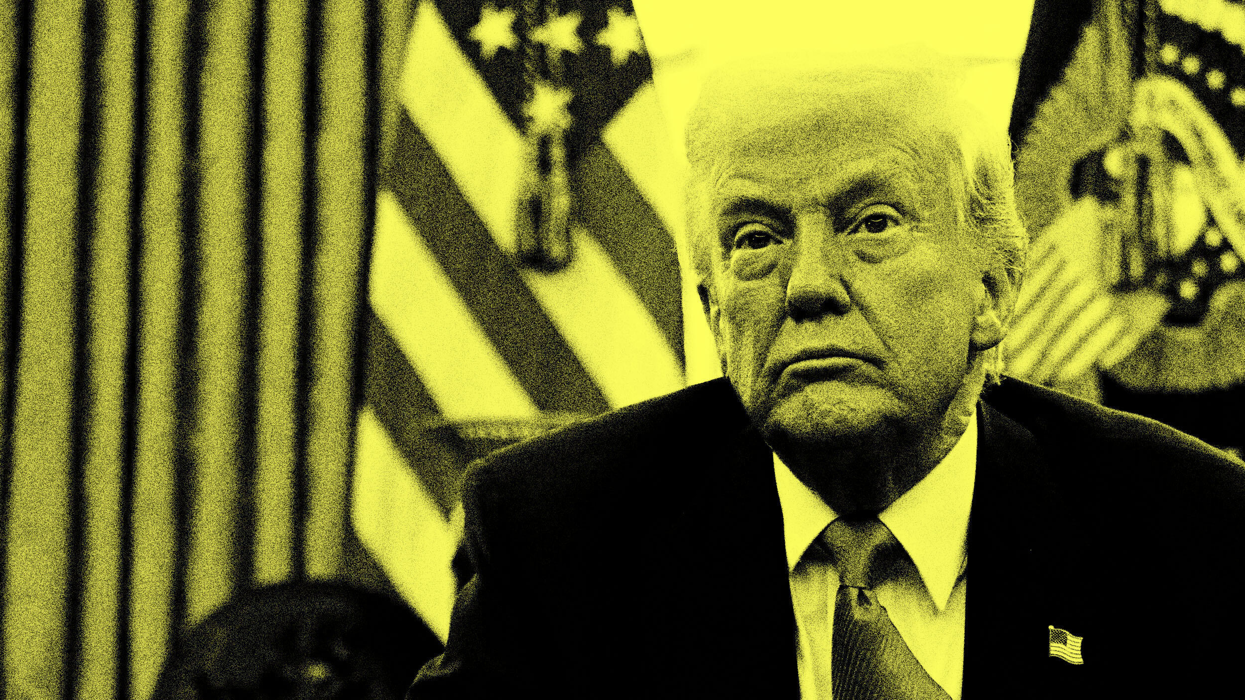 A man in a suit sits in front of American flags, his face partially shadowed and filtered in yellow tones.