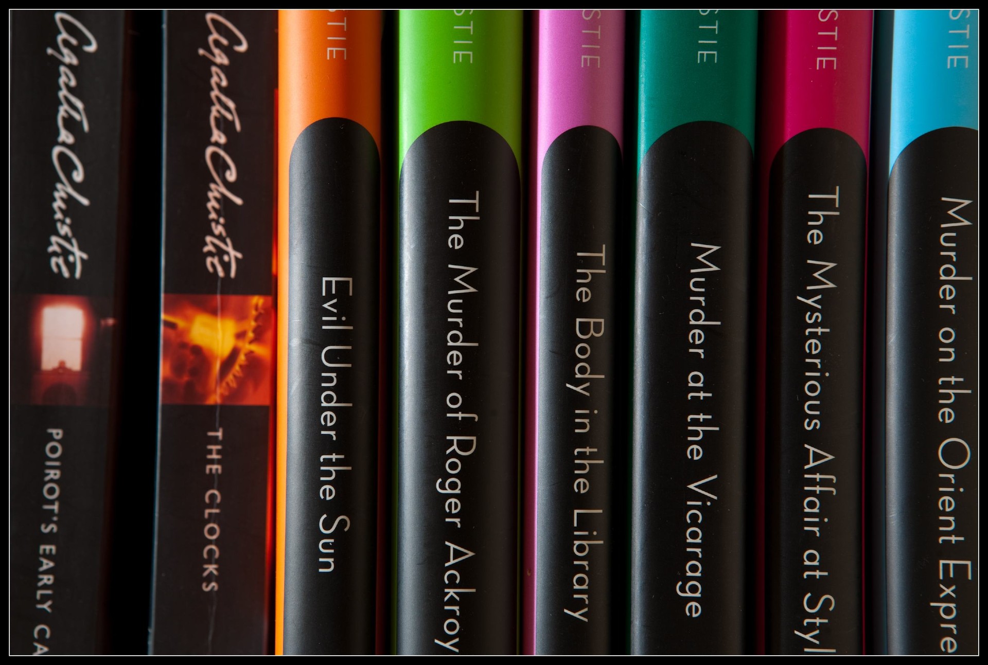 Close-up of several Agatha Christie books arranged upright on a shelf, showing colorful spines and visible titles including "Evil Under the Sun" and "Murder on the Orient Express.