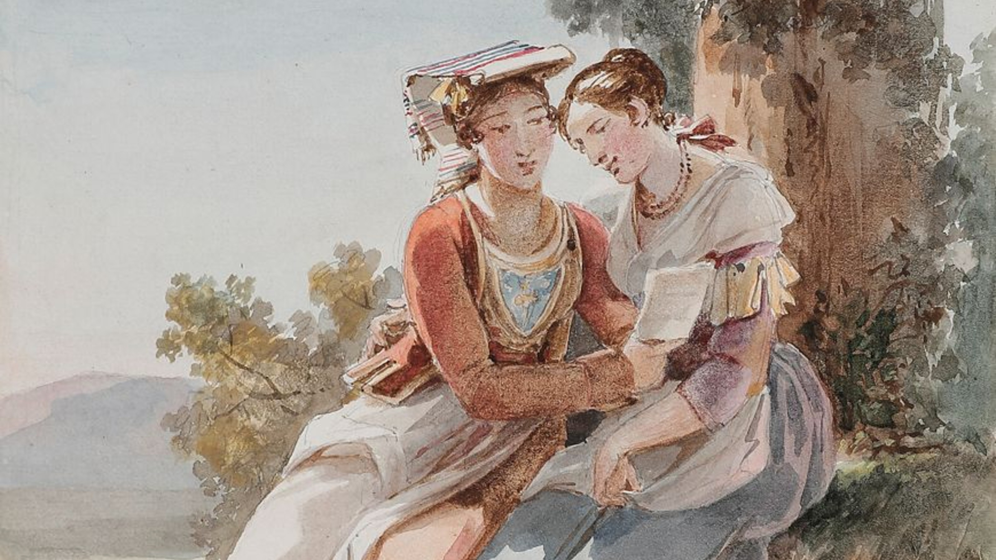 Two women in historical clothing sit outdoors, one holding a book while the other leans in, both appearing to read together near a tree.