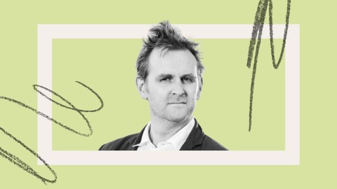 A man in a suit looks at the camera with a neutral expression, set against a light green background with abstract black scribble accents.