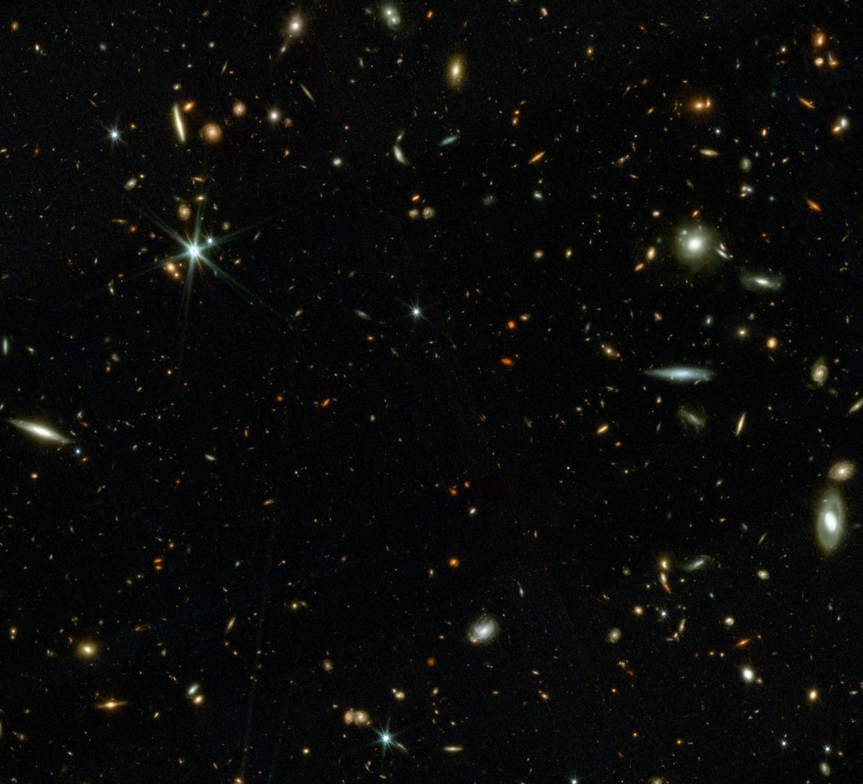A view of deep space from the JWST shows numerous distant galaxies of various shapes and sizes scattered across a dark background, with stars also visible, revealing new frontiers in science.