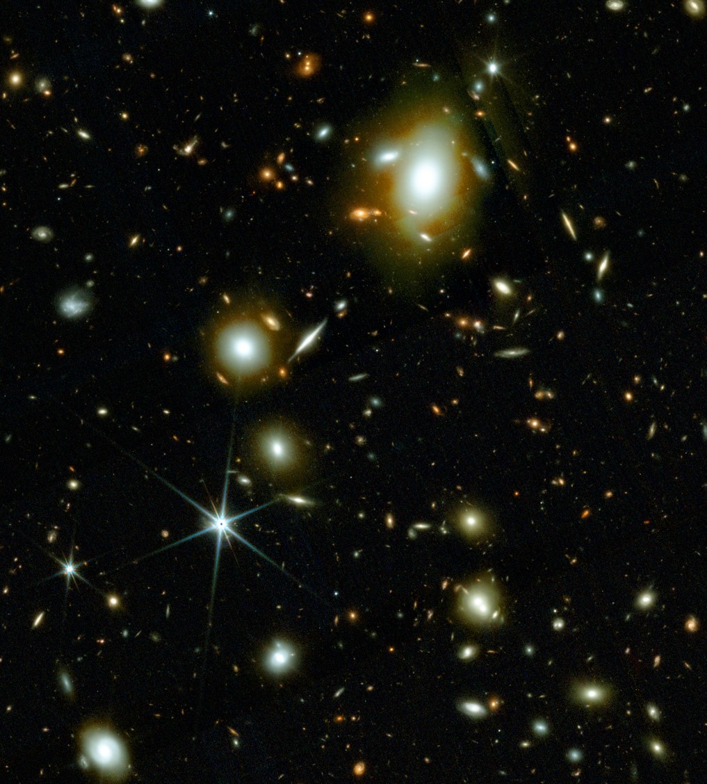 Image shows a deep space view with numerous bright galaxies and stars scattered against a dark background, captured by JWST. Some galaxies appear clustered and elongated, highlighting the wonders of modern science.