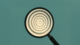 A magnifying glass focusing on concentric circles against a plain teal background.