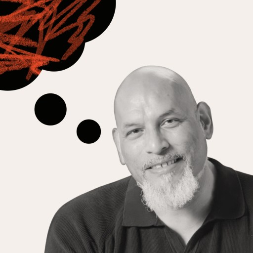 A man with a bald head and gray goatee smiles at the camera. Above his head, a thought bubble filled with red scribbles hints at the inner thoughts of John Amaechi.