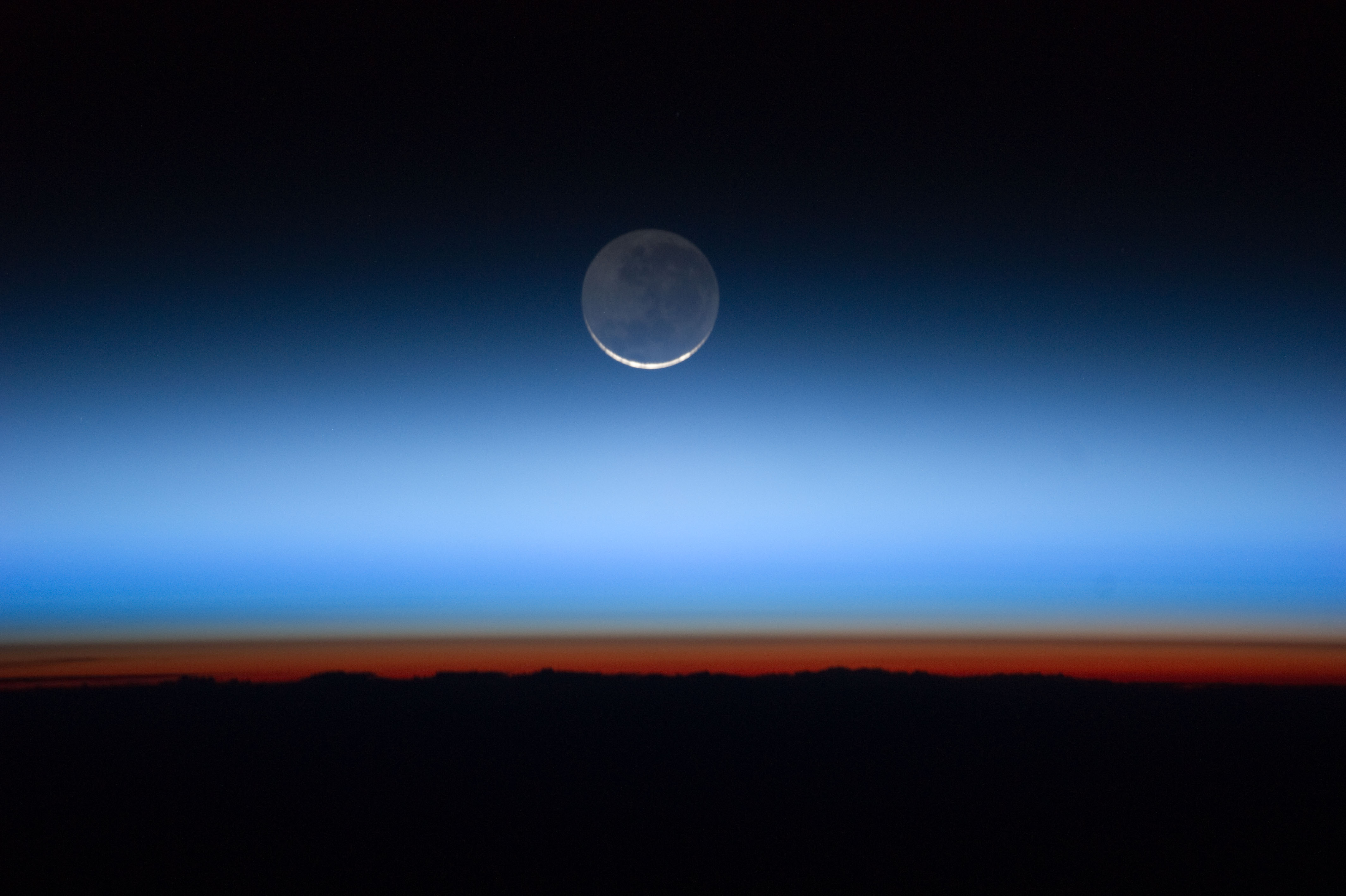 A crescent moon is visible above the horizon with a gradient sky transitioning from dark blue to orange—perfect for inspiring 5 science lessons about the moon at sunrise or sunset.
