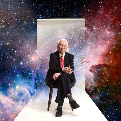 An older man in a suit and red tie sits on a chair against a white backdrop, with a colorful outer space scene in the background.
