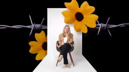 A woman sits on a chair in a studio with a neutral backdrop, overlaid with yellow flowers and barbed wire against a black background.