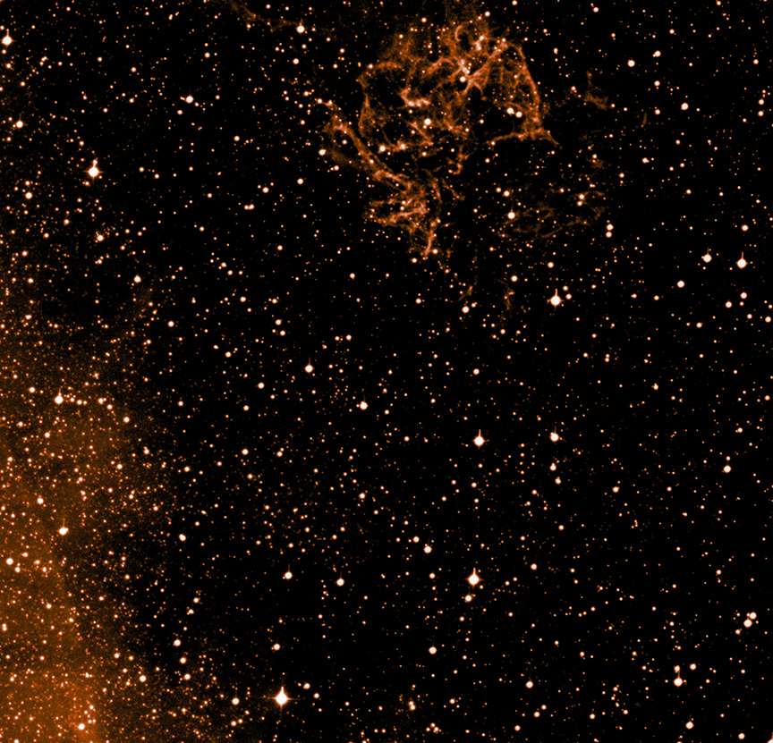 A star field in space with dense clusters of bright stars and nebula-like formations, including a dead star that appears to carve the hand of god near the top and left edges against a dark background.
