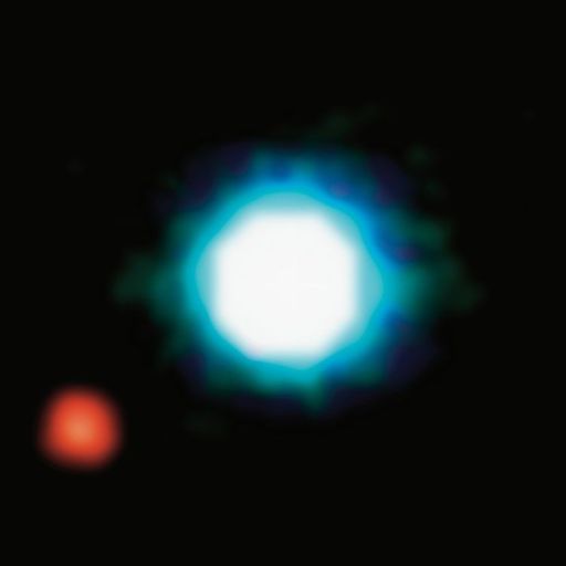 A bright, circular blue and white object is centered against a black background, with a smaller red object to the lower left.