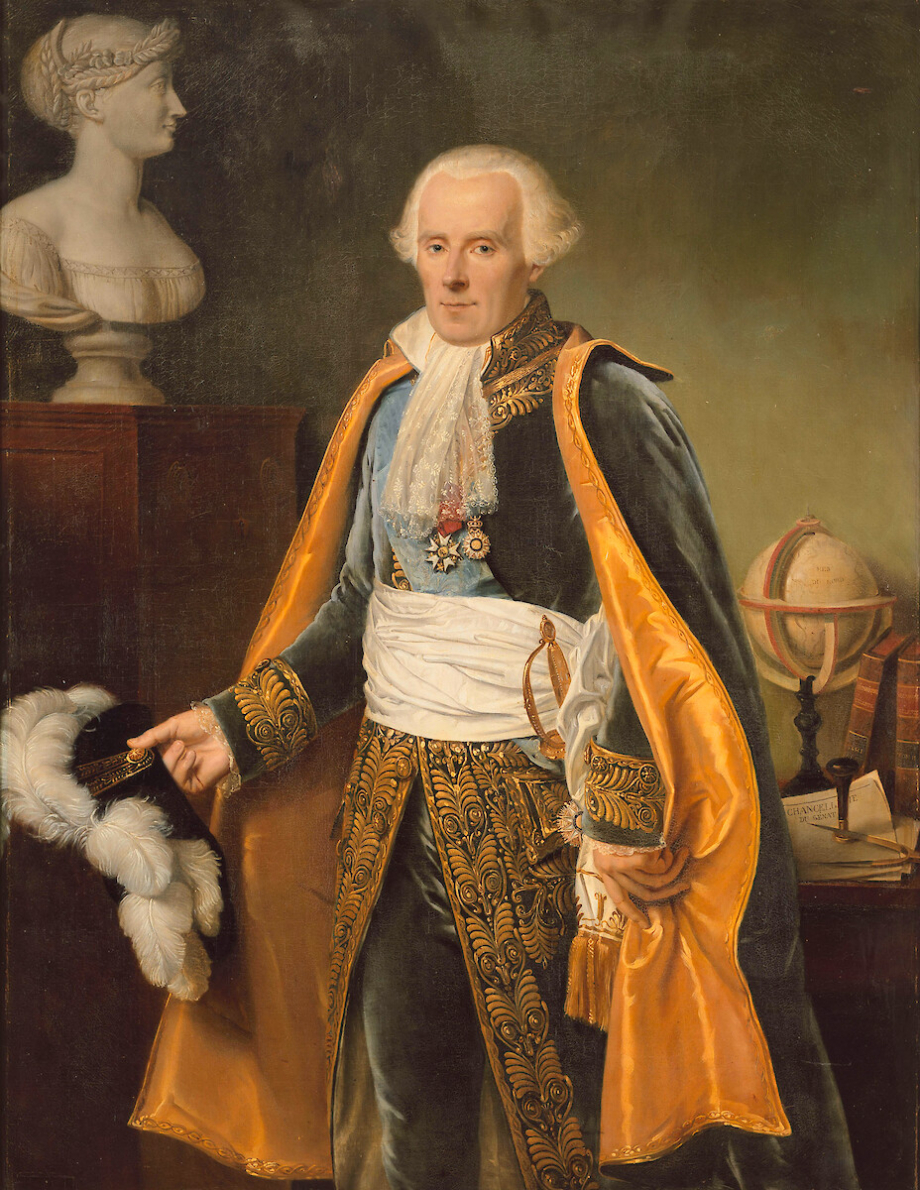 A man in ornate 18th-century attire stands indoors beside a desk with books, papers, a globe, and a bust. He holds a feathered hat in his left hand.
