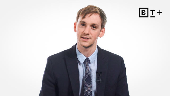 A man in a suit and tie sits facing the camera against a plain white background with a “BT+” logo in the top right corner.