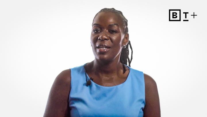 A woman in a blue sleeveless top speaks, wearing a lapel microphone. The background is white with a "B T +" logo in the top right corner.