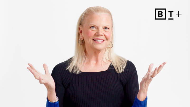 A woman with long blonde hair and hoop earrings is smiling and gesturing with her hands against a plain white background. A logo with the letters "B T +" appears in the top right corner.