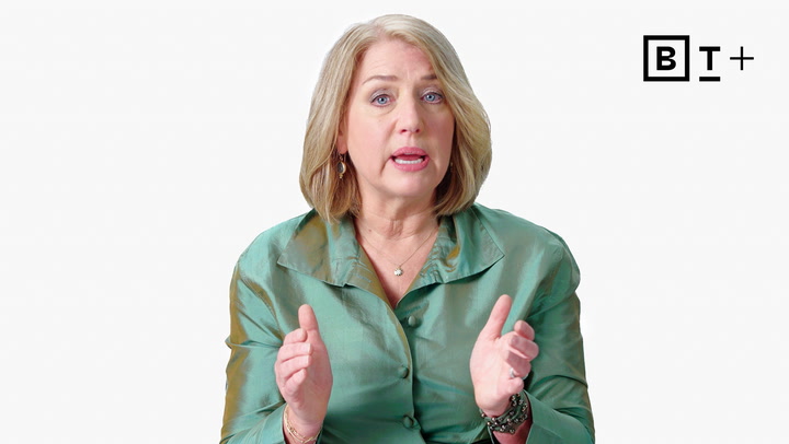 A woman with blonde hair in a green blouse gestures with her hands while speaking. A "BT+" logo appears in the top right corner against a plain white background.