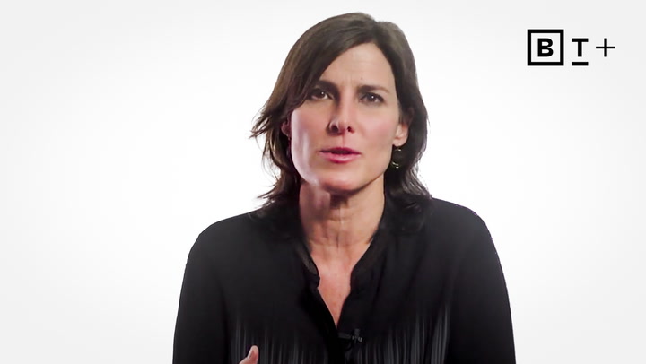 A woman with shoulder-length dark hair wearing a black blouse speaks in front of a white background with the B+T logo in the top right corner.