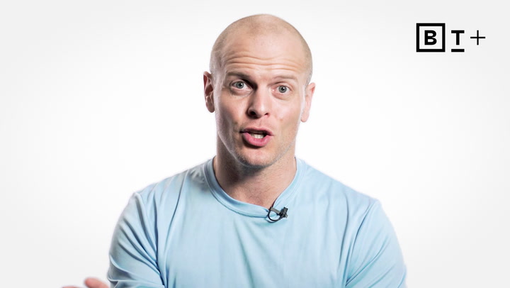 A bald man in a light blue shirt sits in front of a white background, wearing a lapel microphone. The B+ logo appears in the top right corner.