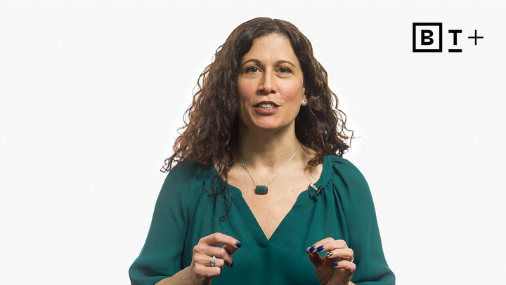 A woman with curly brown hair in a teal blouse speaks, gesturing with her hands, in front of a white background with a "BT+" logo in the top right corner.