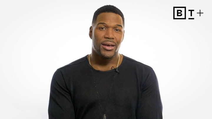 A man wearing a black shirt sits in front of a plain white background with a "B T +" logo in the top right corner.