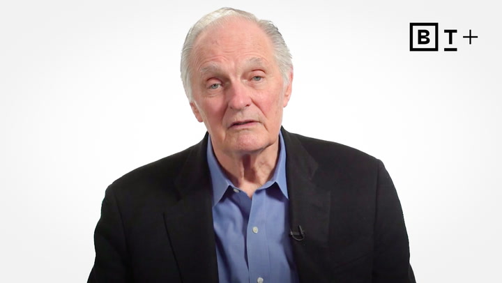 An older man in a dark blazer and blue shirt sits in front of a plain white background with the "BT+" logo in the top right corner.