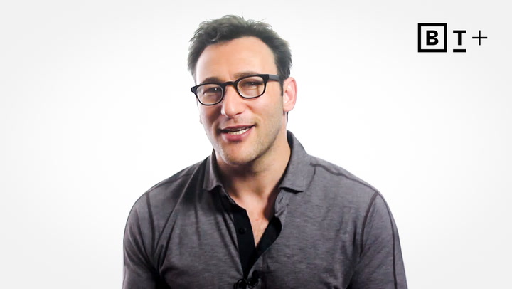 A man with short brown hair and glasses wearing a grey polo shirt sits in front of a plain white background with a "B T +" logo in the top right corner.