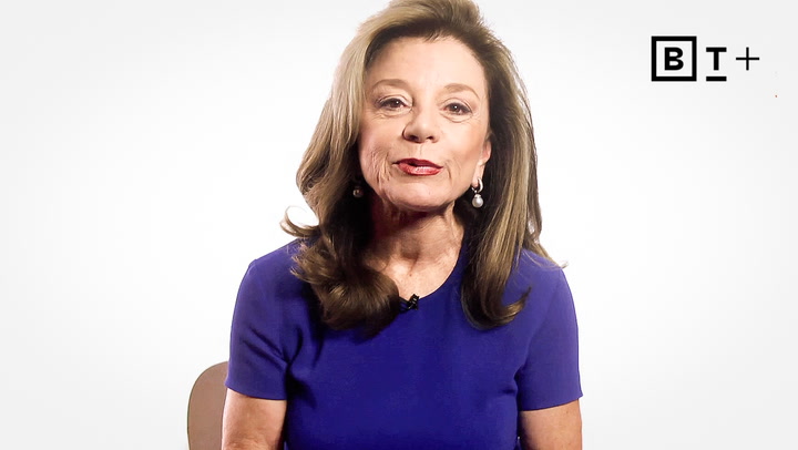 A woman with long brown hair wearing a blue top sits in front of a white background with the BT+ logo in the upper right corner.