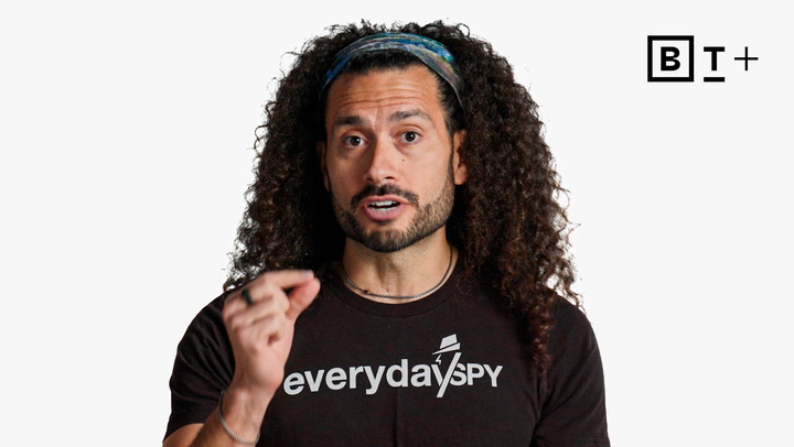 A person with long curly hair wearing a headband and a black "everydayspy" t-shirt speaks while gesturing, with a B+ logo in the top right corner.