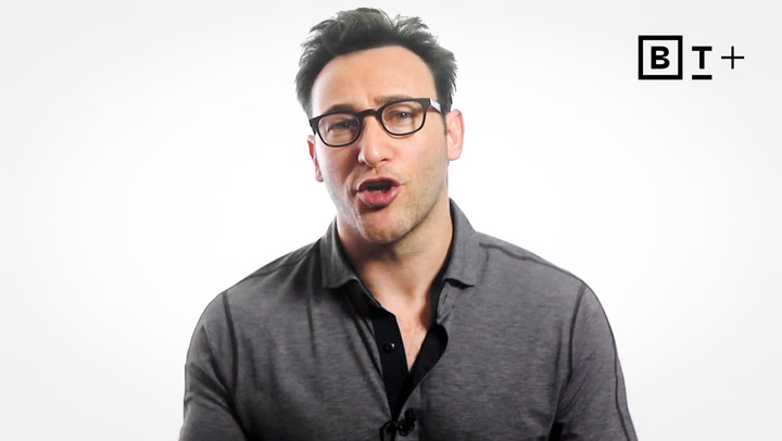 A man with glasses wearing a gray shirt speaks in front of a white background with a "B T +" logo in the top right corner.