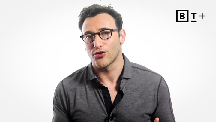 A man with short dark hair and glasses wears a grey collared shirt and speaks in front of a white background with a black "BT+" logo in the top right corner.