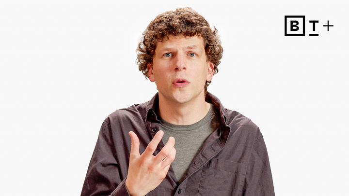 A man with curly hair wearing a dark shirt gestures with his hand while speaking. A "B T +" logo is visible in the top right corner on a plain white background.