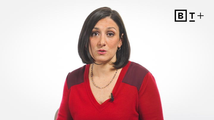 A woman with straight dark hair wearing a red top speaks in front of a white background with the "BT+" logo in the upper right corner.