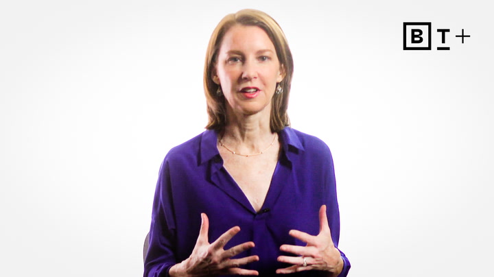 A woman in a purple blouse speaks while gesturing with her hands; a black and white "BT+" logo appears in the top right corner.