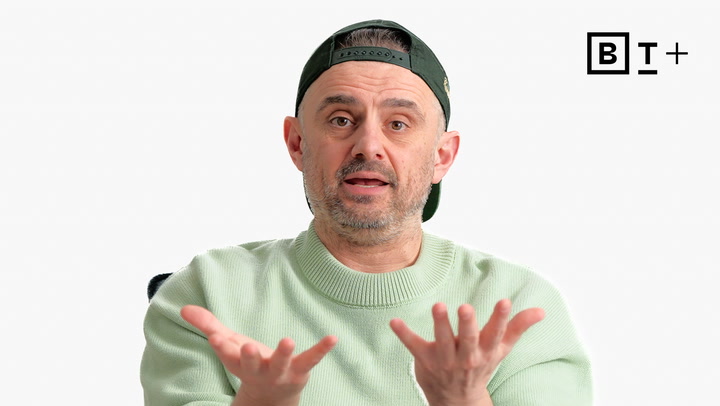 A man in a light green sweater and backwards cap gestures with open palms. The BT+ logo appears in the top right corner on a plain white background.