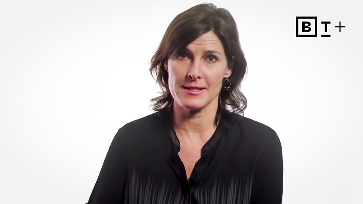 A woman with shoulder-length dark hair, wearing a black blouse, sits in front of a white background with a "BT+" logo in the top right corner.