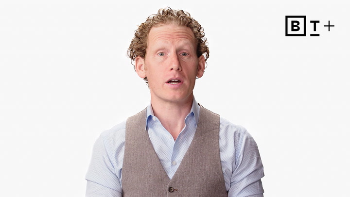 A man with curly hair wearing a light blue shirt and gray vest speaks in front of a white background with the "BT+" logo.