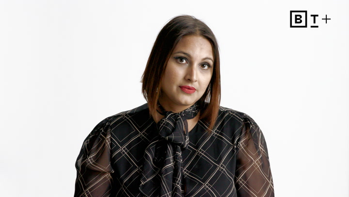 A woman with straight, shoulder-length hair wears a black, patterned blouse and looks at the camera against a plain white background. The BT+ logo is in the top right corner.