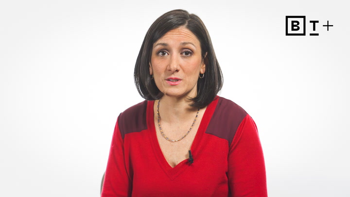 A woman with straight dark hair, wearing a red top and a necklace, sits in front of a plain white background with a "BT+" logo in the top right corner.
