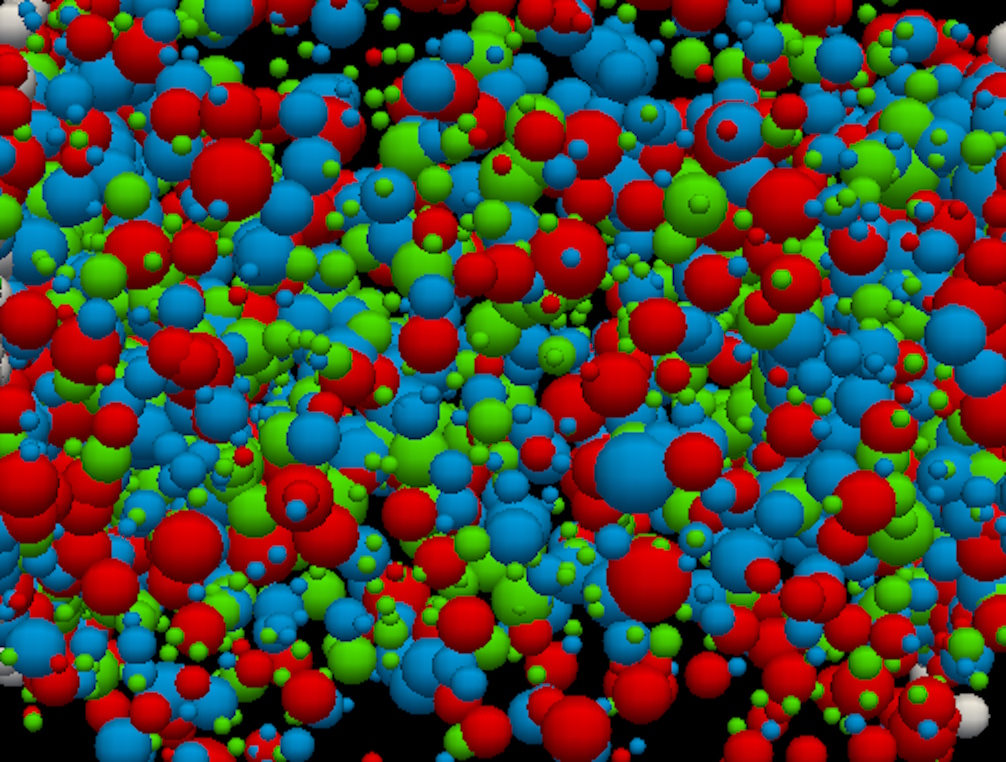 A dense cluster of differently sized red, blue, and green spheres overlaps against a black background, evoking the biggest mysteries surrounding the origin of the universe.