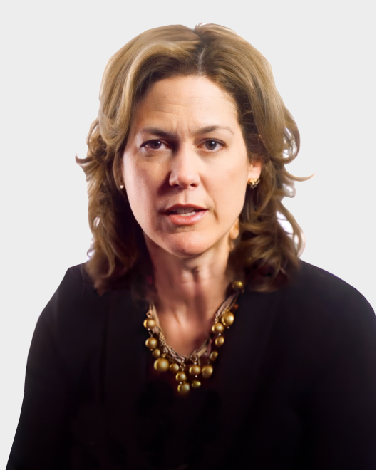A woman with shoulder-length wavy hair wearing a black top and a gold necklace, looking forward against a plain background.