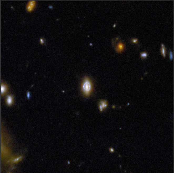 A distant galaxy, captured by COSMOS-Web with JWST, appears as a bright circular Einstein ring created by gravitational lensing, surrounded by faint stars and galaxies in deep space.